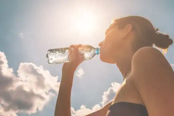 Hydration: The Secret Ingredient for a Toned Stomach and Enhanced Fitness 3 Image of woman drinking water to hydrate after run.